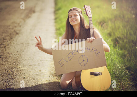 Beautiful hippie woman on a country road . Freedom and journey concept Stock Photo