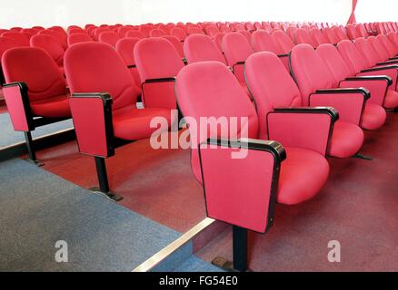 Interior view of a lecture hall wit rows of red chairs Stock Photo