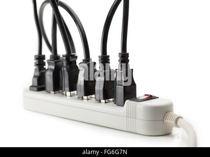 Many electrical cords connected to a power strip or extension block. Isolated on white. Stock Photo