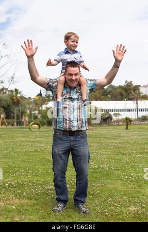 Happy daddy and his son having fun in the park outdoors. Happiness, fatherhood and childhood concept. Stock Photo