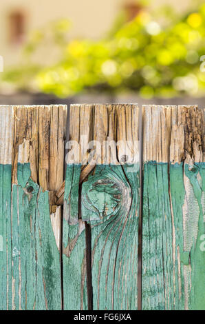 Vintage wooden fence with blurry plants in background Stock Photo