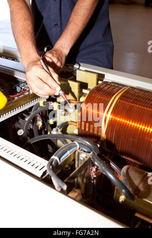 Engineer works in an electrical control cabinet in the plant Stock Photo