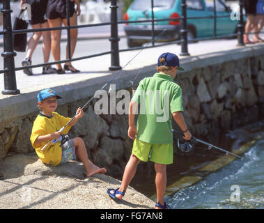 Young boys fishing in harbour, Es Cana, Ibiza, Balearic Islands, Spain Stock Photo