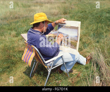 Male artist painting landscape near Aldeburgh, Suffolk, England, United Kingdom Stock Photo