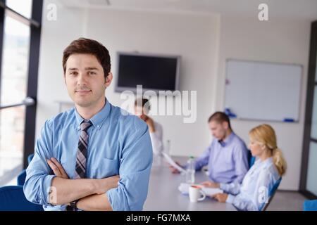 business man  on a meeting in offce with colleagues in background Stock Photo