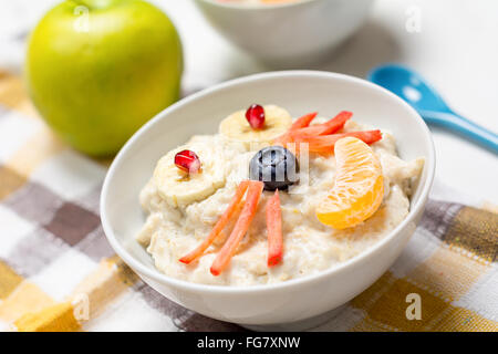 Oatmeal porridge decorated with fresh berries and fruits for children healthy breakfast Stock Photo