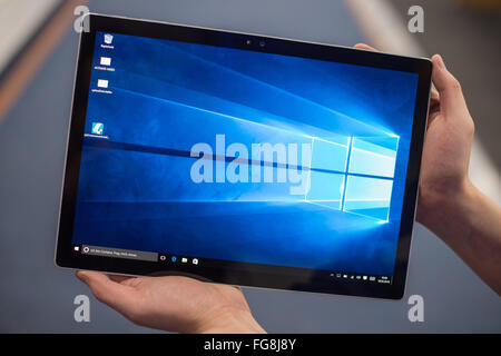 Hamburg, Germany. 18th Feb, 2016. ILLUSTRATION - A man holds up a Microsoft Surface Book as a tablet in an electronics store in Hamburg, Germany, 18 February 2016. The Surface Book has a touch screen that also allows it to be used as a tablet. Photo: LUKAS SCHULZE/dpa/Alamy Live News Stock Photo