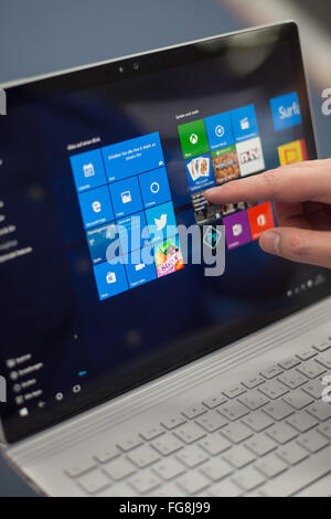 Hamburg, Germany. 18th Feb, 2016. ILLUSTRATION - A man demonstrates how to operate a Microsoft Surface Book in an electronics store in Hamburg, Germany, 18 February 2016. The Surface Book has a touch screen that also allows it to be used as a tablet. Photo: LUKAS SCHULZE/dpa/Alamy Live News Stock Photo
