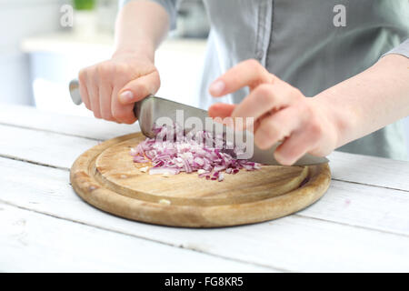 Woman cut red onion  on the kitchen counter . Chopping onions for salads. red onion Stock Photo