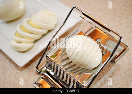 Slicing a Boiled Egg with a Plate in the Background Stock Photo