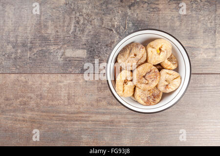 Dried figs in a bowl on wooden background. Stock Photo