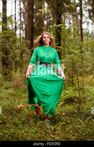 Running woman in long dress at forest. Stock Photo