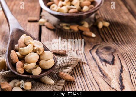 Mixed roasted and salted nuts (selective focus) on an old wooden table Stock Photo