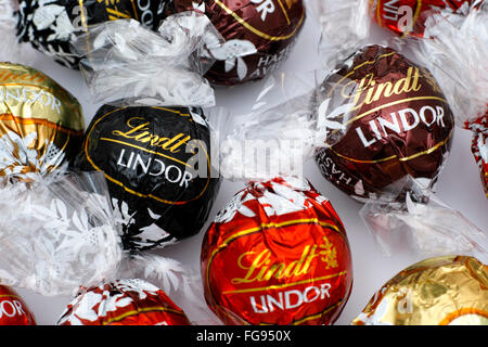 Lindt Lindor chocolate truffles on white background. Lindor assorted balls: the Lindt milk, dark and white chocolate candies. Stock Photo