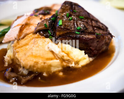 Steak, potatoes, and gravy on a white plate Stock Photo