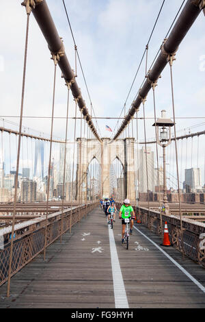 people engaged in bike run on brooklyn bridge new york with manhattan in the background Stock Photo