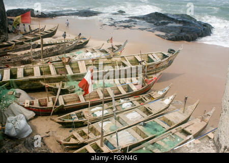 Pirogues, traditional wooden boats, sit on a beach ready for a day of fishing. Stock Photo