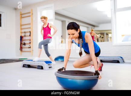 Two fit attractive women in gym doing various exercises Stock Photo