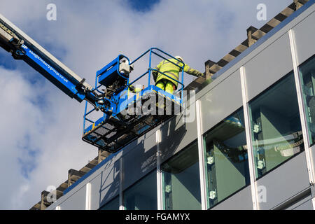 Two male construction workers working at height during building works on University Of Nottingham campus Stock Photo