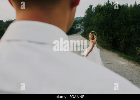 bride leads groom on the road Stock Photo