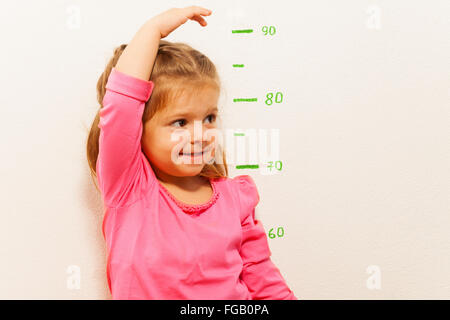 Height measurement by little girl at the wall Stock Photo