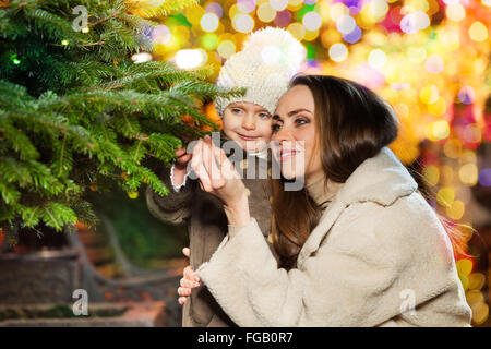 Smiling mother and daughter near Christmas tree Stock Photo