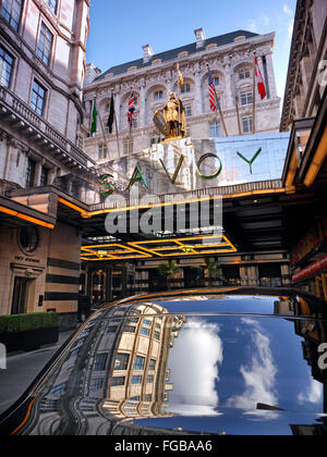 SAVOY HOTEL Exterior view of luxury Five-Star Savoy Hotel entrance foyer with sky reflection in Rolls Royce motorcar The Strand London WC2 Stock Photo