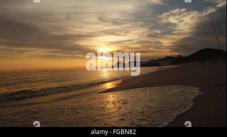 Beautiful sunset on Praia de Piratininga beach, Brazil. Copacabana and Christ the Redeemer in the background. Stock Photo