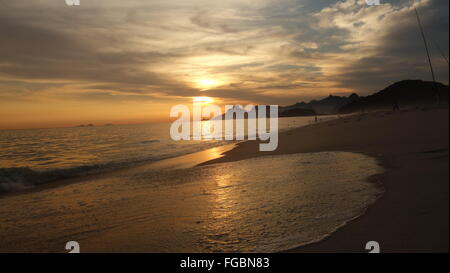 Beautiful sunset on Praia de Piratininga beach, Brazil. Copacabana and Christ the Redeemer in the background. Stock Photo