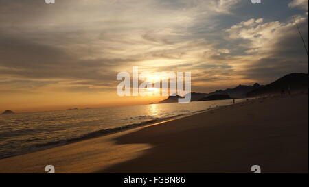 Beautiful sunset on Praia de Piratininga beach, Brazil. Copacabana and Christ the Redeemer in the background. Stock Photo