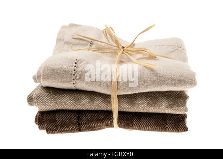 Linen cloth napkins in brown and beige natural colors folded and tied with string isolated on white background Stock Photo