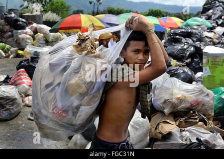 Poor boy collecting garbage in his sack to earn his livelihood