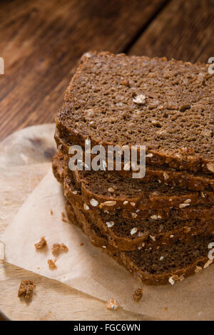 Brown Bread (sliced) on an old wooden table (selective focus)