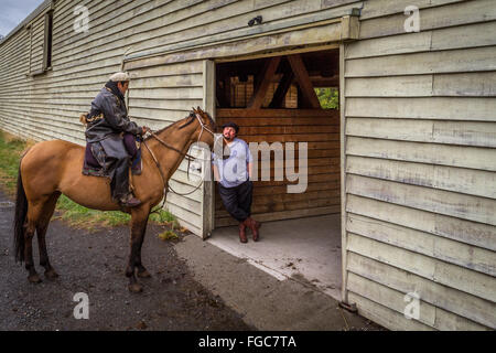 Two gauchos at a stable, one on a horse, Torres del Paine National Park, Patagonia, Chile, South America Stock Photo