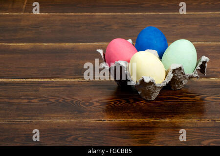 Colorful easter eggs in stand over wooden background Stock Photo