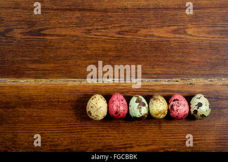 Colourful various quail eggs over wooden background