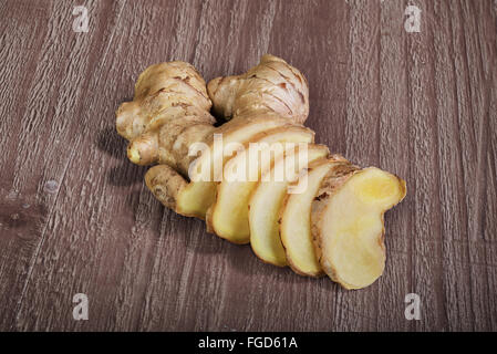 Ginger root slices on vintage wooden background Stock Photo