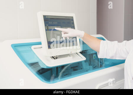 Lab tech loading samples into a chemistry analyzer Stock Photo
