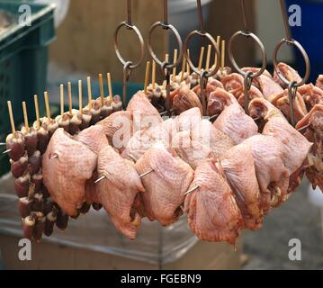 Large pieces of raw chicken meat are put on metal skewers for a barbeque Stock Photo