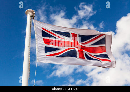 Union Jack Flag on a flag pole blowing in the wind. Stock Photo