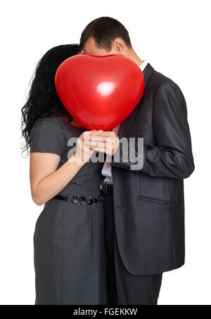 Happy couple kissing and hiding behind red heart shaped balloon ...