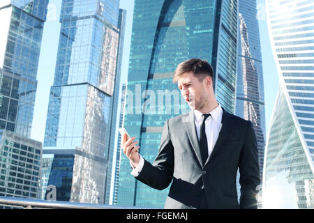 Businessman using smartphone on skyscraper background Stock Photo