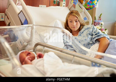 Worried Teenage Girl With Crying Newborn Baby In Hospital Stock Photo