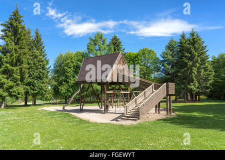 Deserted playground with wooden house on a glade in the forest. Taken on the Rossberg above Albstadt, Swabian Alps, Germany Stock Photo