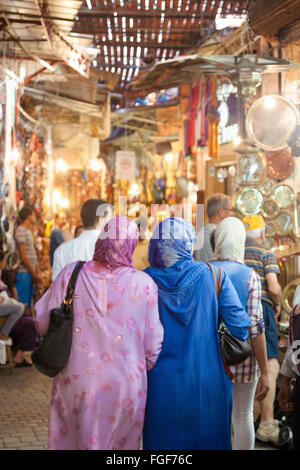 Two muslim moroccan women wearing the traditional dress going shopping in the suk /medina of Marrakesh. MoroccoNorth Africa Stock Photo