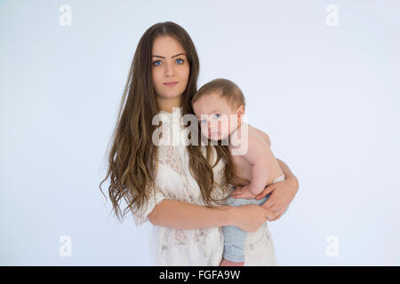 Mother holding baby boy in arms smiling Stock Photo