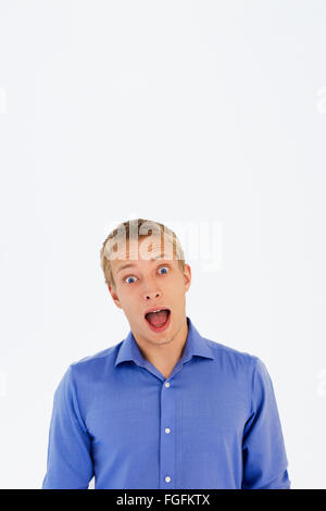Man with blonde hair and blue eyes wearing a blue business shirt shouting Stock Photo