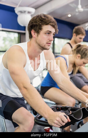 Fit group of people using exercise bike together Stock Photo