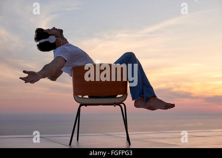 relaxed young man at home on balcony Stock Photo
