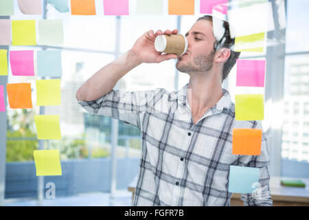 Hipster in front of post-it drinking coffee Stock Photo